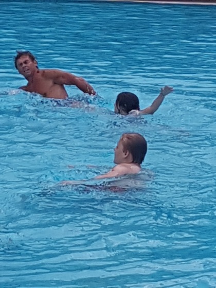 Jugendliche und Trainer schwimmen