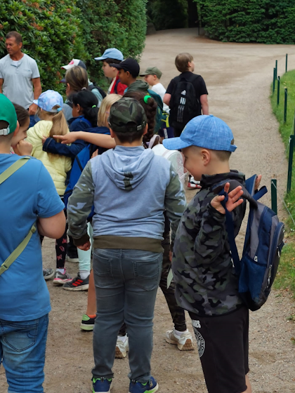 Kinder und der Sensei auf einem Weg im Tierpark