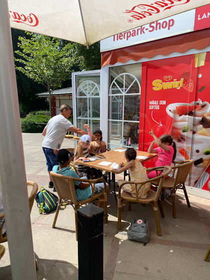 Kinder und der Sensei an einem Tisch vor dem Tierpark-Shop