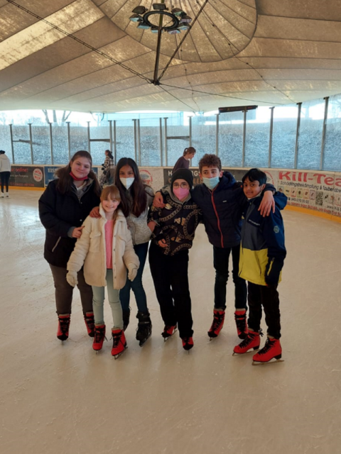 Jungen und Mädchen posieren auf dem Eis
